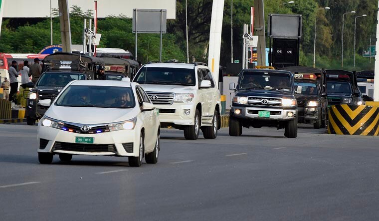 Security members escort a vehicle, center, carrying Pakistan's former Prime Minister Imran Khan after his arrest, crossing Islamabad Motorway Toll Plaza, in Islamabad, Pakistan, Saturday Aug. 5 2023. Pakistani police on Saturday arrested Khan at his home in the eastern city of Lahore after a court convicted him in an asset concealment case and handed him down a three-year prison sentence. (AP/PTI) (AP08_05_2023_000228A)