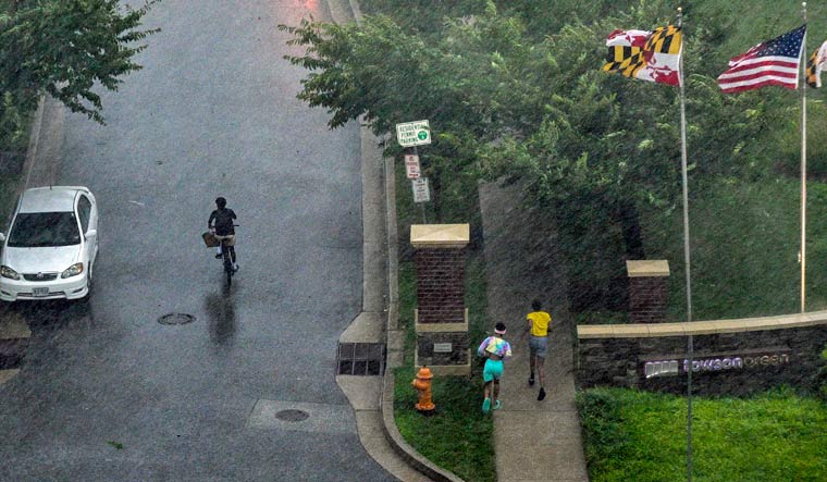 People sprint for shelter as a line of thunderstorms hit downtown Towson, Md., Monday, Aug. 7, 2023 | AP