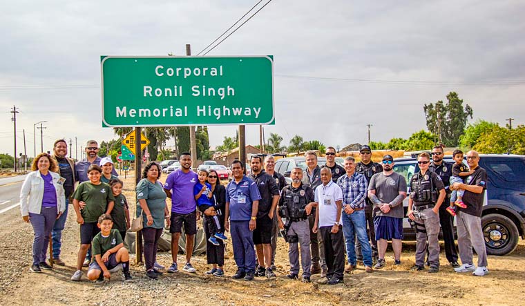 Family members and friends of Indian-origin police officer, who was shot dead while conducting a traffic stop in 2018, pose for photos in front of a signage proclaiming the 'Corporal Ronil Singh Memorial Highway' during a ceremony to unveil the sign, in California, USA, Saturday, Sept. 2, 2023 | PTI