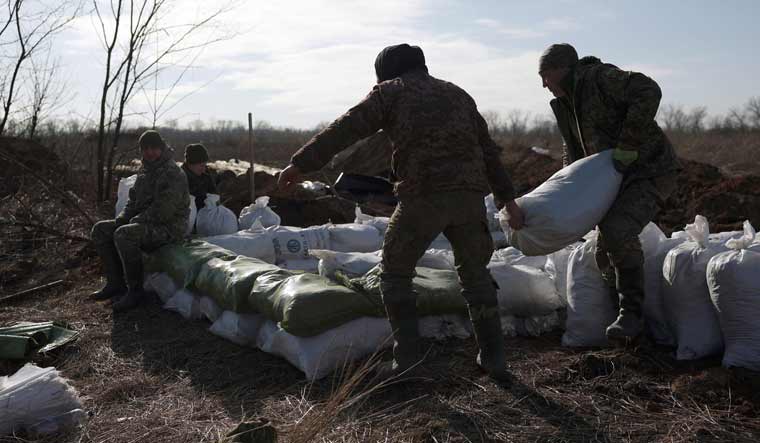 Ukrainian servicemen pile up earthbags to build a fortification not far from town of Avdiivka in the Donetsk region, amid the Russian invasion of Ukraine | AP