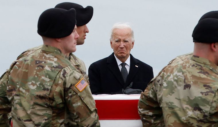 US President Joe Biden places his hand over his heart as a US Army carry team moves a flagged draped transfer case containing the remains of Army Sgt. Breonna Moffett during a dignified transfer at Dover Air Force Base in Delaware on February 2, 2024 | Getty Images via AFP