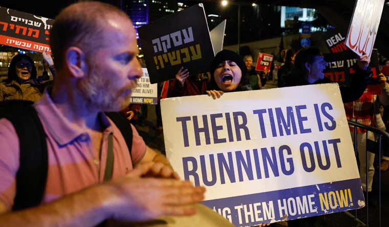 People hold banners as they take part in a protest demanding a hostage deal amid the ongoing conflict between Israel and the Palestinian Islamist group Hamas, in Tel Aviv, Israel | Reuters