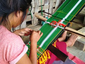A Manipuri woman working a traditional loom | Shutterstock
