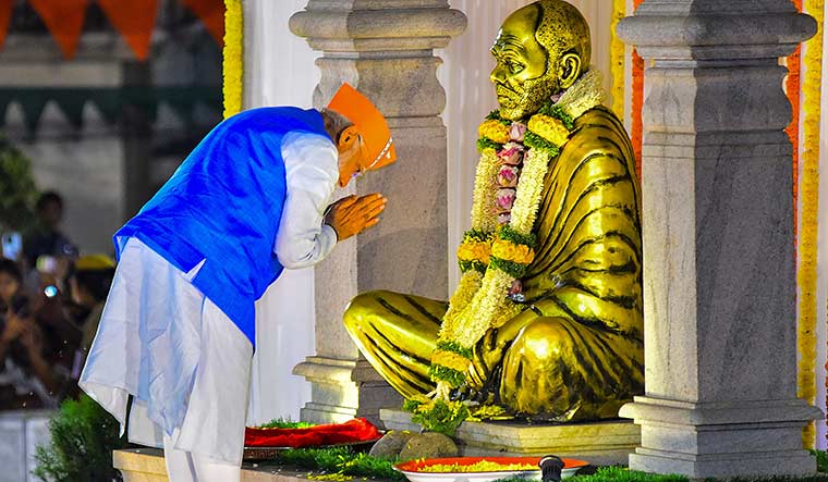 Divine support: Prime Minister Narendra Modi garlands the statue of Narayana Guru before a roadshow in Mangaluru, Karnataka | PTI