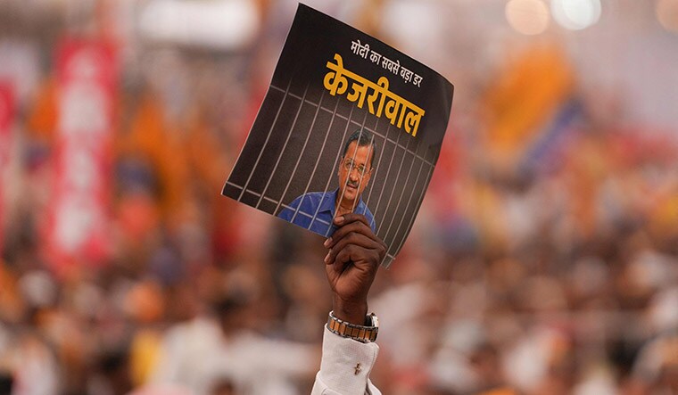 Broom bristles: A Kejriwal supporter at the INDIA bloc rally in Delhi on March 31 holds up a sign that reads: ‘Kejriwal is Modi’s biggest fear’ | AFP