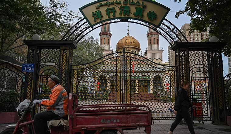 Religion versus state: People walk past a mosque in Urumqi, the regional capital of Xinjiang | AFP