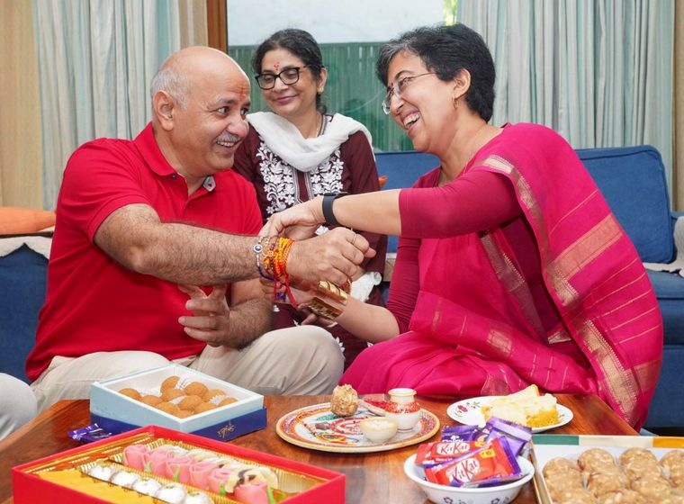 Family affair: Delhi minister Atishi (right) ties rakhi to Sisodia in the presence of his wife, Seema | PTI