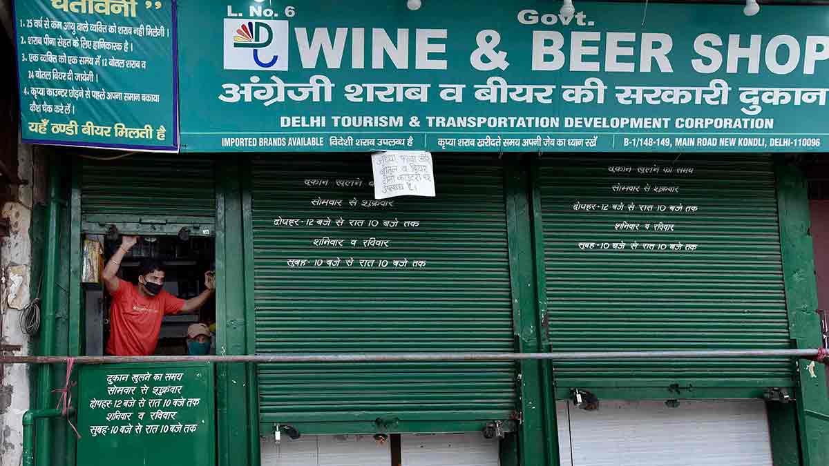 Tough laws: A liquor shop attendant in Delhi pulls down the shutter as police forcibly closed the shop | Getty Images