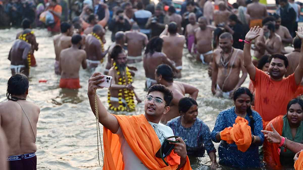 Going with the flow: A devotee takes a selfie with his family after a holy dip in Prayagraj | Getty Images