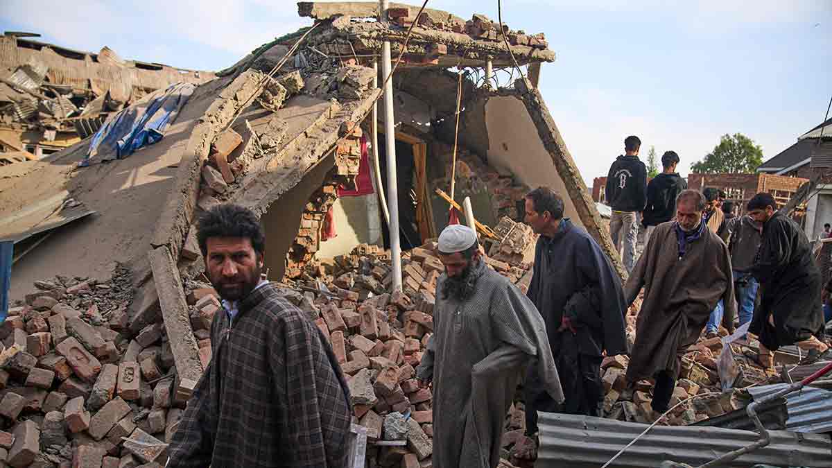 Return fire: Villagers inspect the debris of the destroyed home of suspected LeT operative Ahsan ul-Haq Sheikh in Pulwama | AP