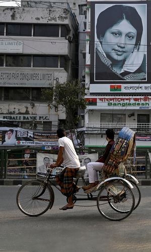 Abiding memory: A man rides his rickshaw past an office of the Bangladesh Nationalist Party displaying a picture of Begum Khaleda Zia in Dhaka a day after the elections | Reuters