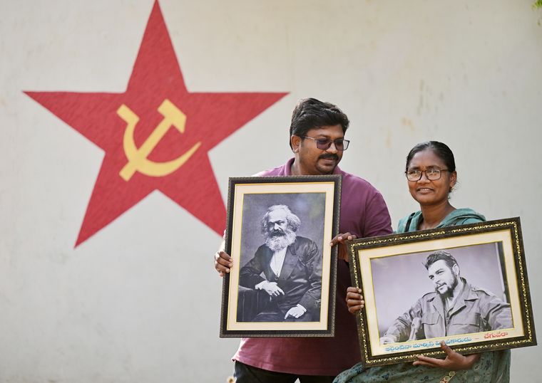 Still standing: Chandu and wife, Soni, at their home with photos of Karl Marx and Che Guevara, respectively.