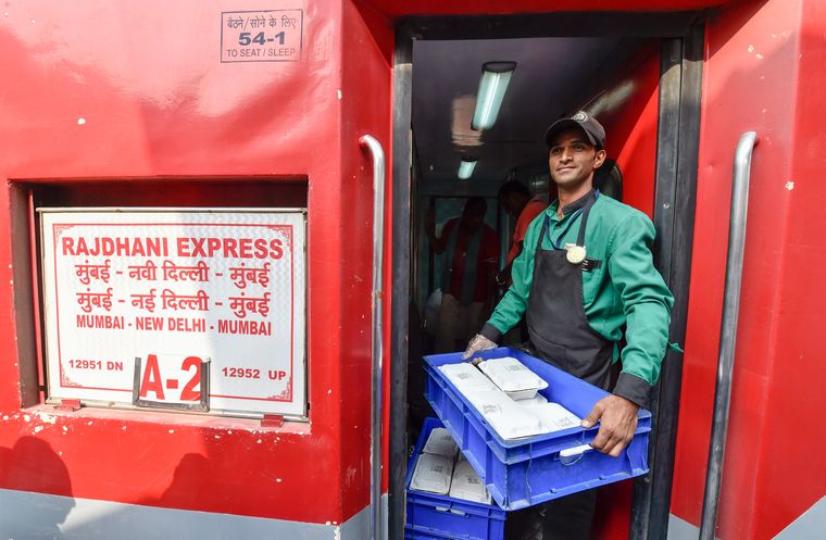 Served with care: An IRCTC worker carries meals inside the Rajdhani Express | AP