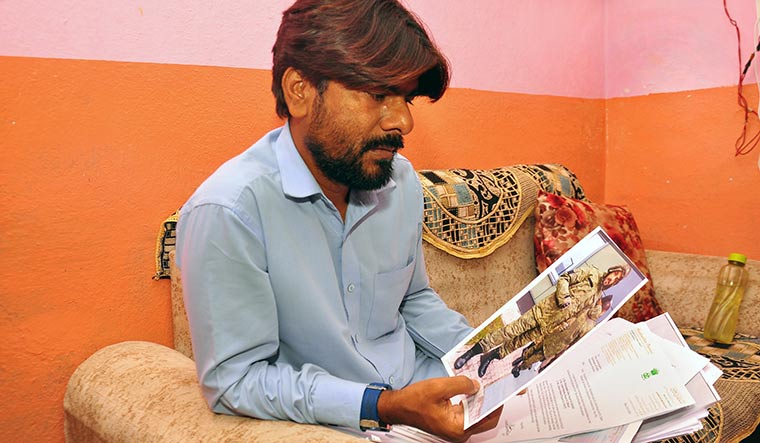 Tryst with danger: Mohammed Imran looks at a photograph of his younger brother Afsan, who is serving with the Russian army in the Ukraine war | P. Prasad