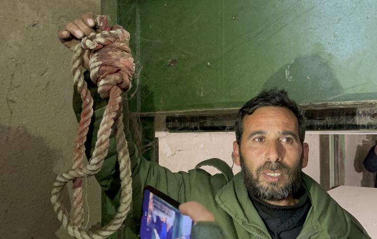 A man holds up a bloody noose | Anagha Subhash Nair/Getty Images