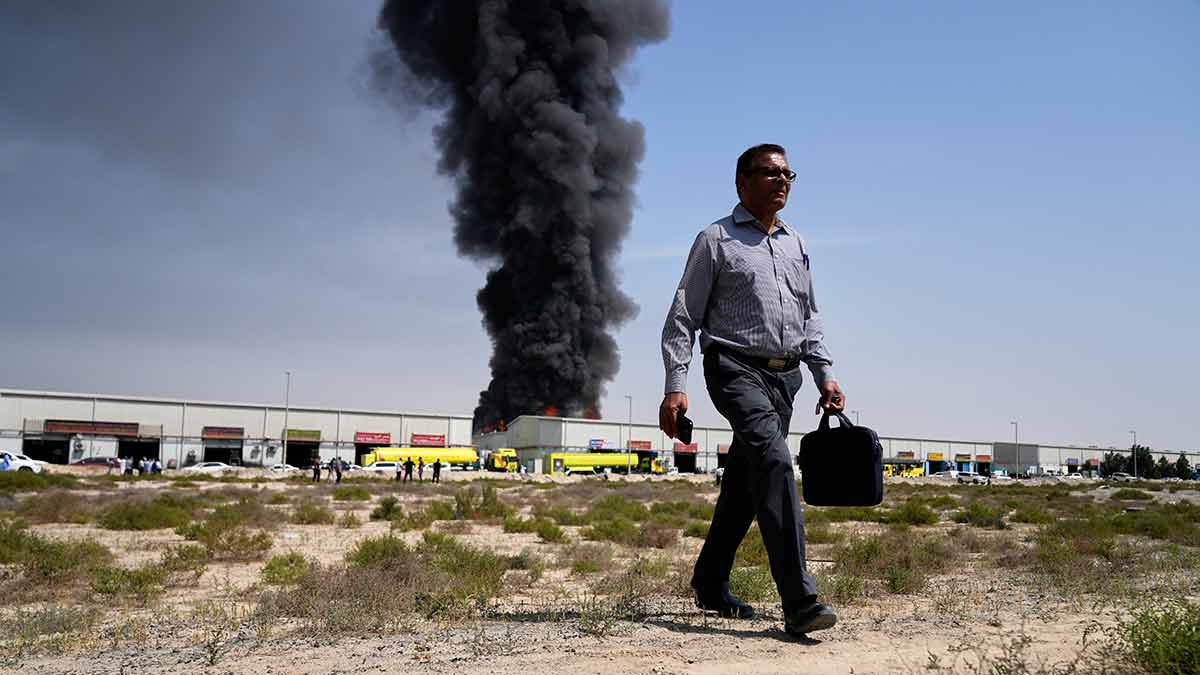New normal: A man walks away from smoke rising from a warehouse in Sharjah; the UAE has been a major target of strikes in the ongoing conflict | AP