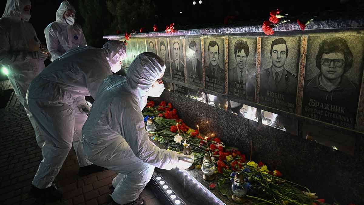 Warm tribute: People dressed in hazmat suits, representing liquidators, in front of a memorial for Chornobyl victims in the town of Slavutich on April 26, 2026 | AFP
