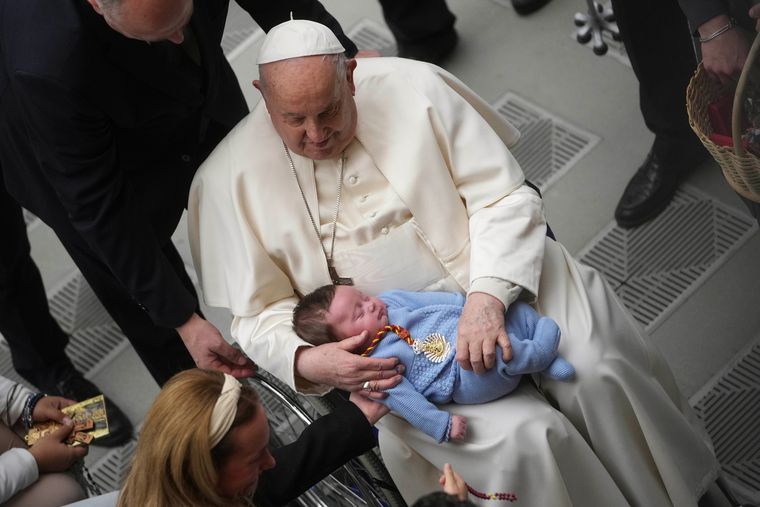 Heart of gold: Francis holds a baby during his weekly general audience at the Vatican, earlier this year | AP