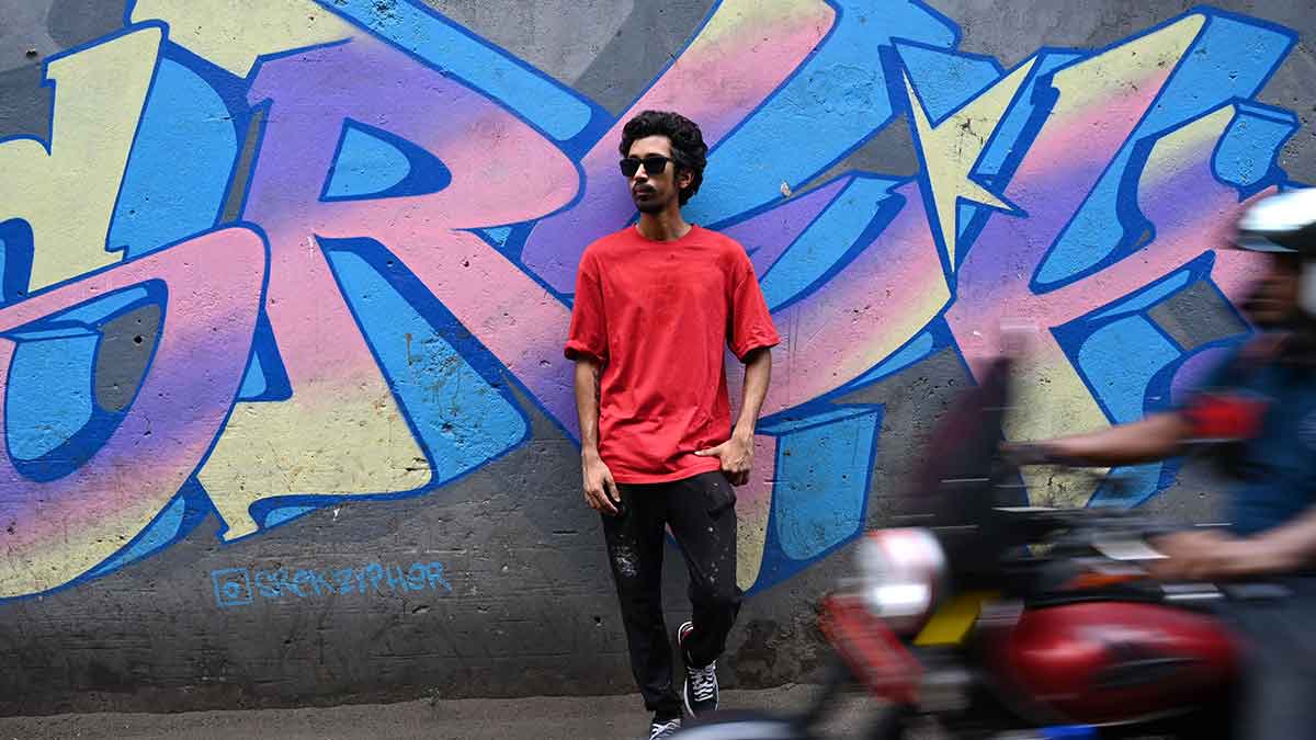 Paint it red: Justin, a graffiti artist in Kolkata, in front of one of his works | Sail Bera