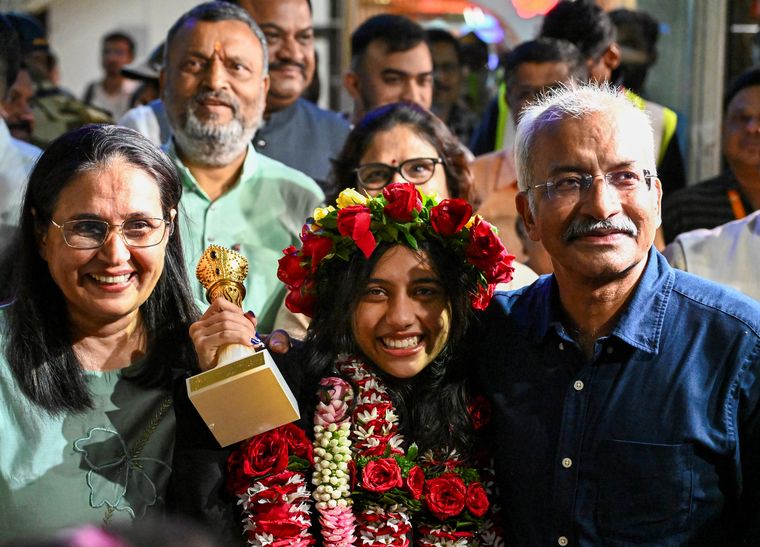 Top of the world: Divya with her parents on her return to Nagpur | PTI