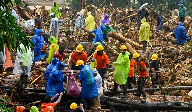 Tracing trapped lives: Relief personnel carry the body of a victim during a rescue operation following landslides in Wayanad on July 30 | AFP