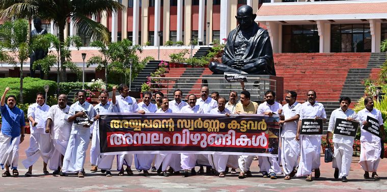 Show of belligerence: Opposition leaders staging a protest outside the assembly by holding a banner that labels the culprits as “temple thiefs” | Manoj Chemancheri