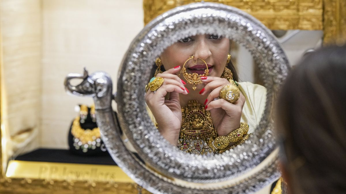 A woman tries gold ornaments at a jewellery showroom | PTI