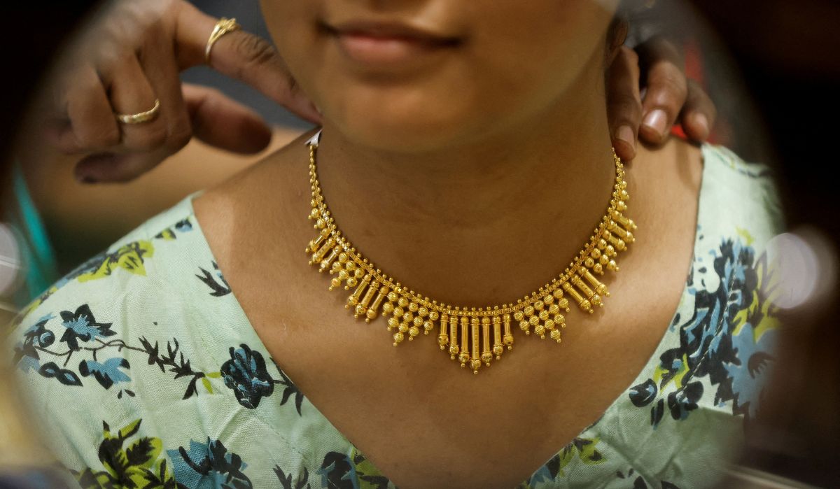 A woman tries on a gold necklace at a jewellery shop during Dhanteras in Mumbai Reuters - 1