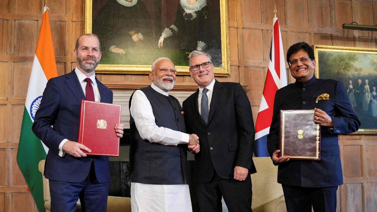 British PM Keir Starmer (centre right) and India PM Narendra Modi (centre left) shake hands next to UK Business Secretary Jonathan Reynolds (left) and Union Minister of Industries Piyush Goyal (right) holding the Free Trade Agreement on July 24 2025 | AFP