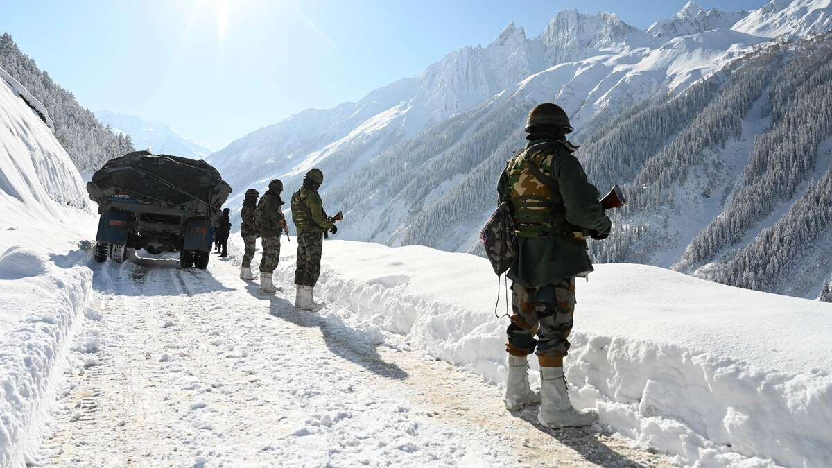 (FILES) Indian army soldiers walk along a road near Zojila mountain pass that connects Srinagar to the union territory of Ladakh, bordering China on February 28, 2021. India said on October 21, 2024 it had struck an agreement with neighbour China for military patrols in highly contested border zones, stalled since their rival armies clashed in 2020. (Photo by TAUSEEF MUSTAFA / AFP)