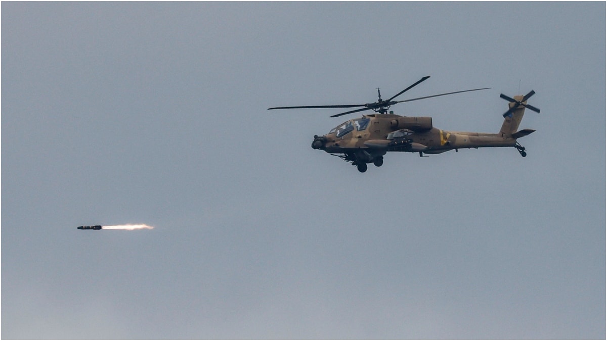 An Israeli Air Force AH-64 Apache attack helicopter fires rockets while flying at a position along the border between northern Israel and southern Lebanon | AFP