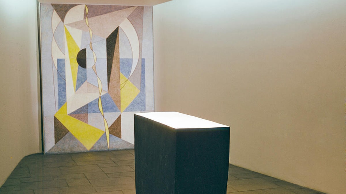 A view of the recently enlarged and remodeled Meditation Room at United Nations Headquarters. The fresco in the background is the work of Swedish artist Bo Beskow. Painted in blue, white, grey and yellow geometric forms, with light pure colours intersecting to form deeper shades, the fresco is 9 feet high and 6.5 feet wide. [1957]