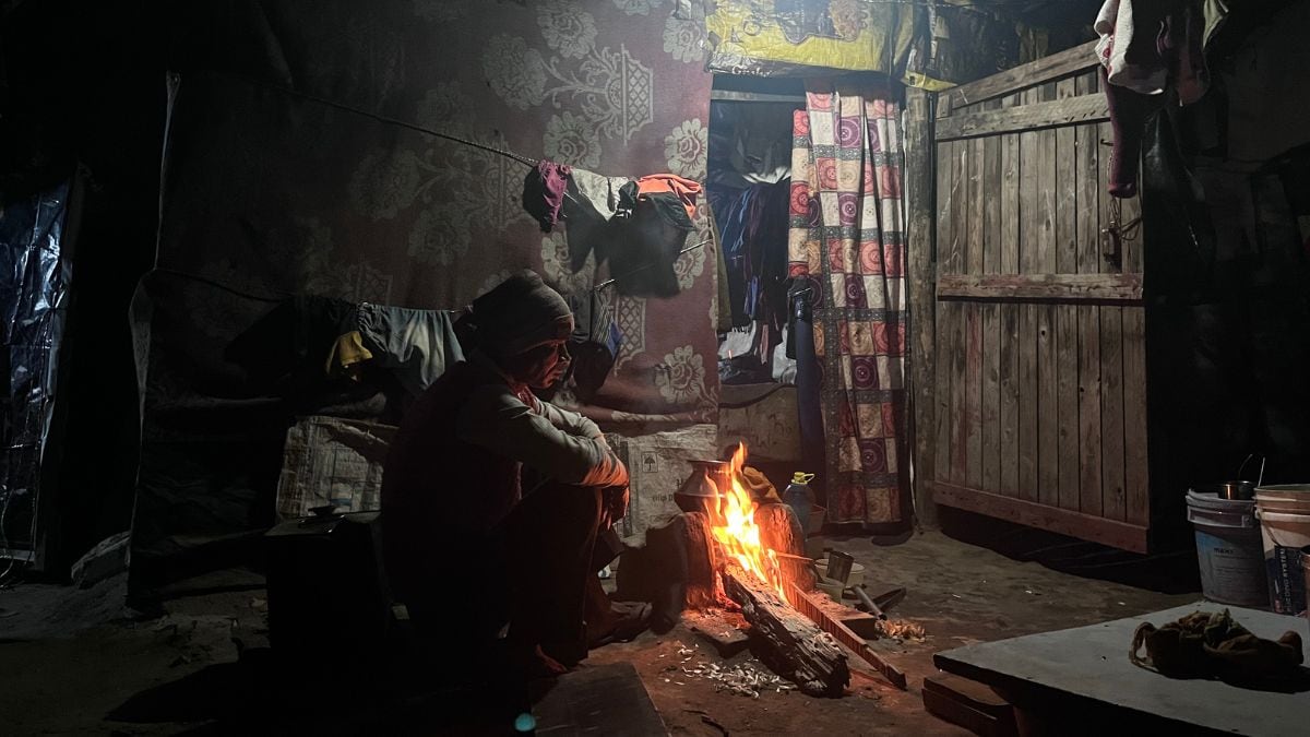 A resident of Chaura Basti sits near a mud stove for warmth during a chilly winter night | Sneha Richhariya/First Check