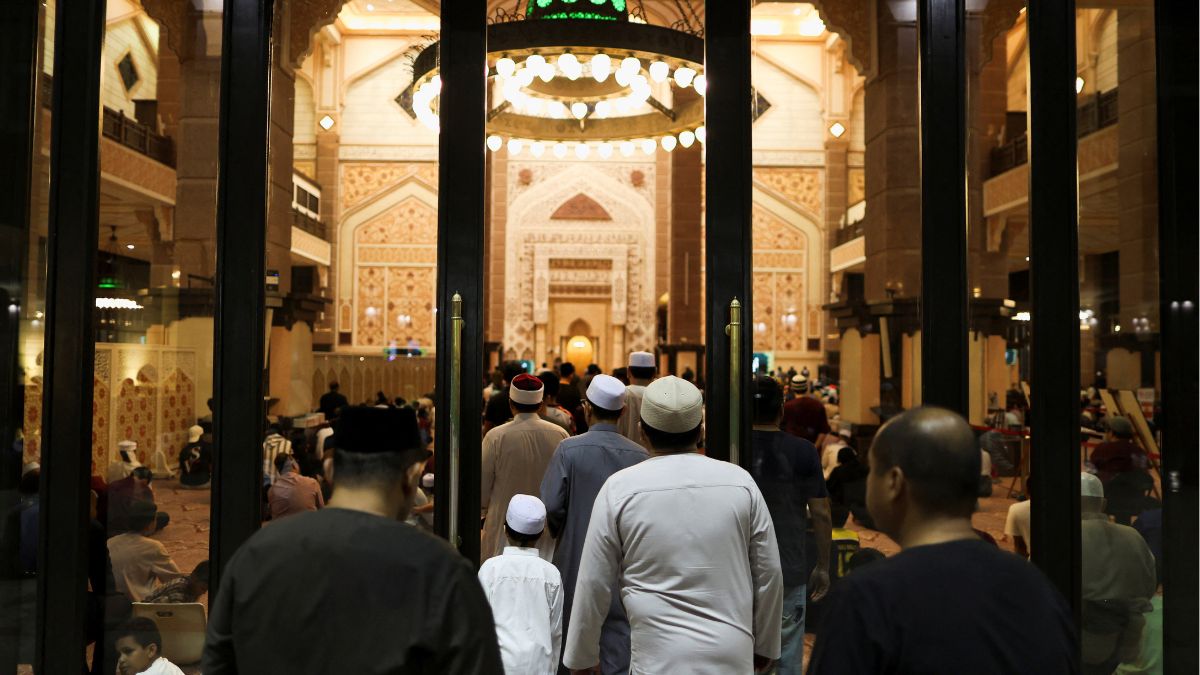 Muslims enter the prayer hall to perform the Tarawih mass prayer on the first evening of the holy fasting month of Ramadan at Putra Mosque in Putrajaya, Malaysia | Reuters