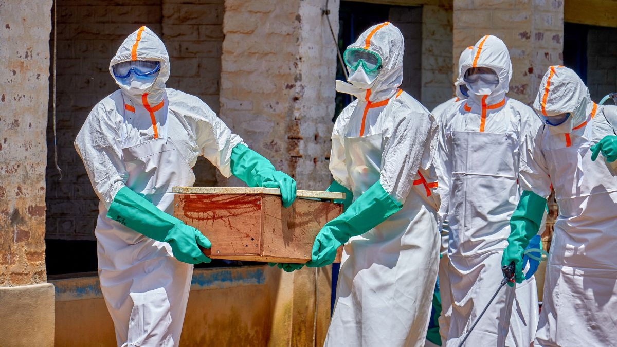 Red Cross workers wearing personal protective equipment (PPE) carry a coffin with the dead body of a child who died of Ebola. REUTERS/Gradel Muyisa Mumbere