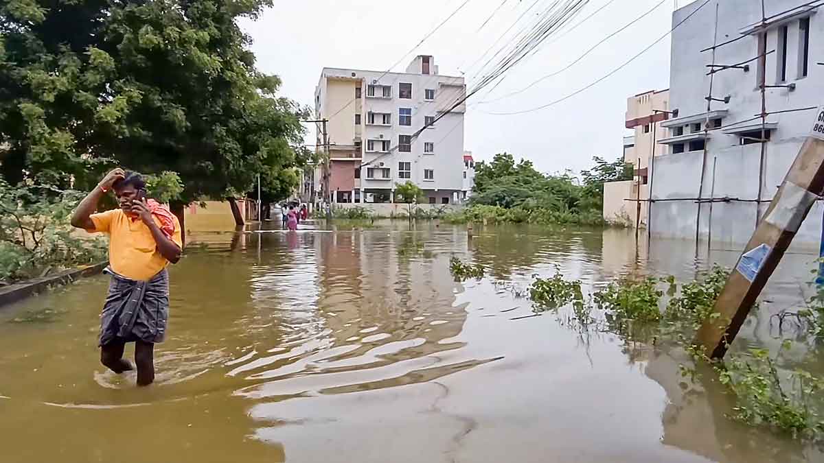 A man crosses a waterlogged street following heavy rains, in Madurai | PTI