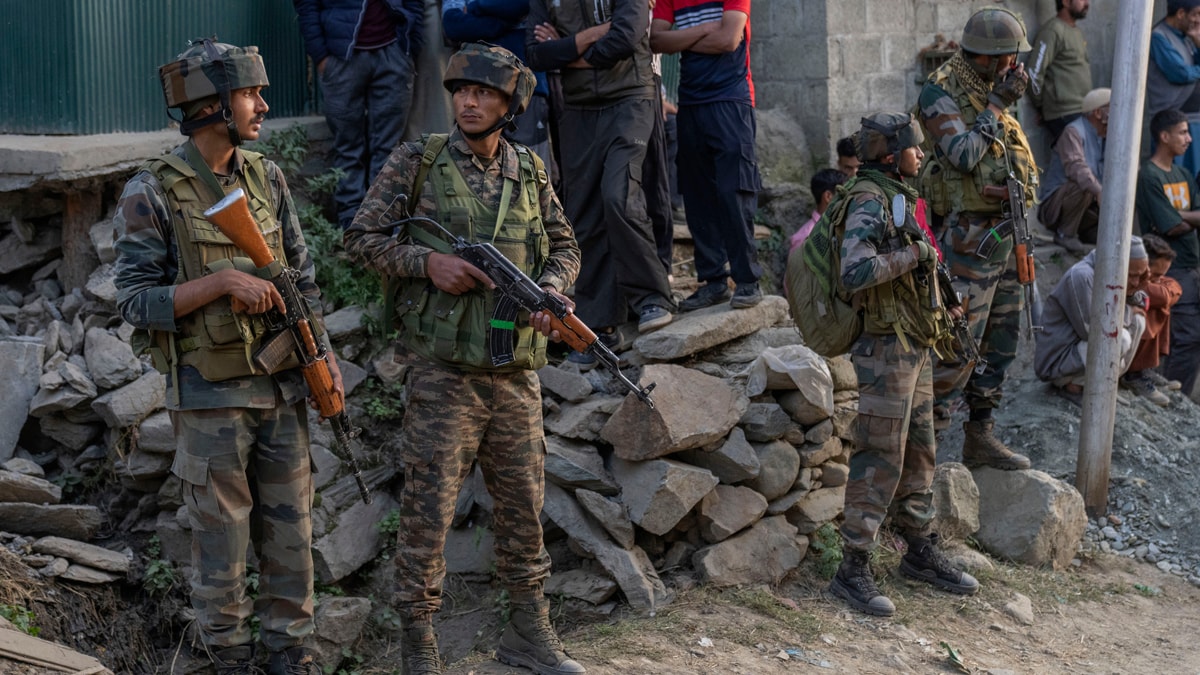 Indian army soldiers stands guard during the funeral of Mushtaq Ahmad, an army porter who was among those killed in a rebel ambush on an army vehicle on Thursday night, in Nowshera village north of Srinagar, Indian controlled Kashmir, Friday, Oct. 25, 2024.(AP Photo/Dar Yasin)