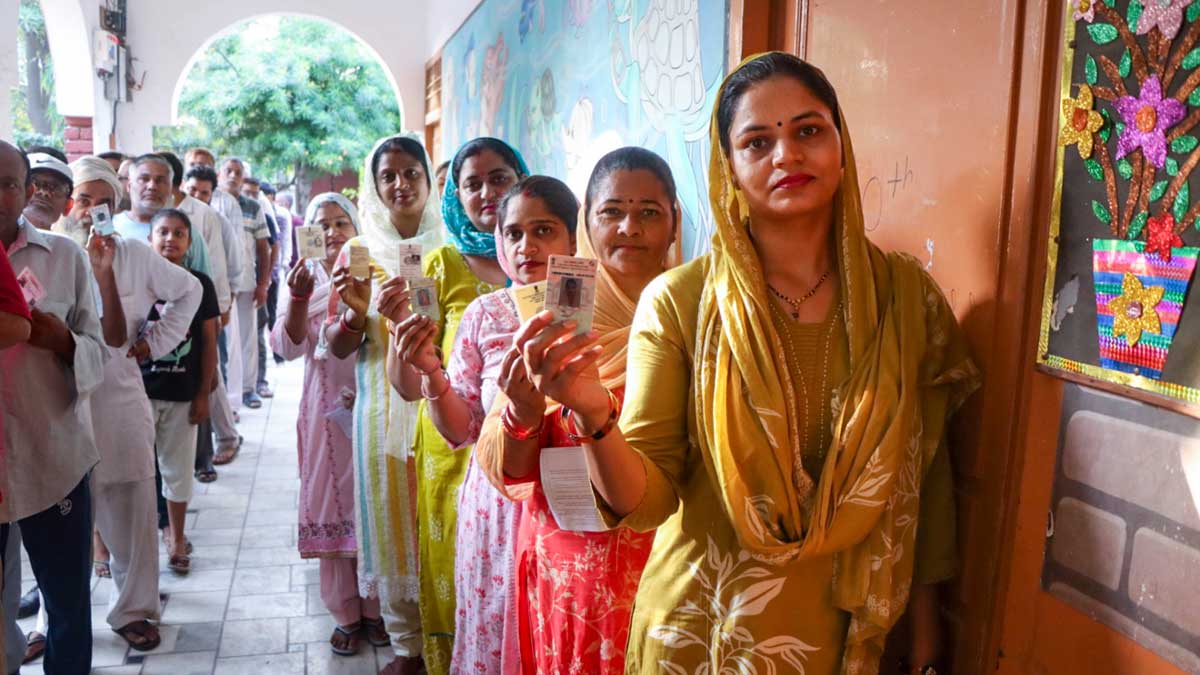 Voters wait in a queue to cast their votes at a polling station during the Haryana Assembly elections, in Rohtak district | PTI
