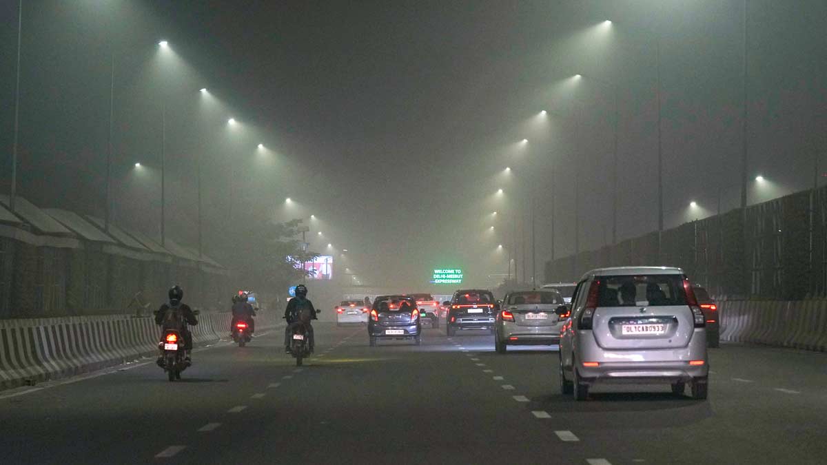 Vehicles move on a road amid low visibility due to dense fog, in New Delhi | PTI