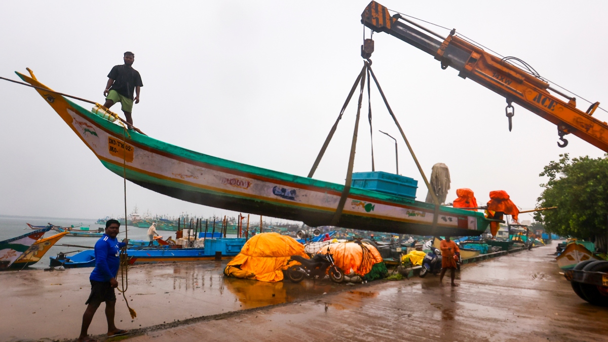 Fishermen move their boat away from the sea during rains along the coast of the Bay of Bengal in Chennai | PTI