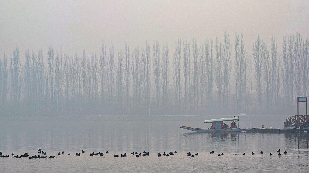 Srinagar: A shikara is seen parked on the banks of the frozen Dal Lake on a cold winter morning, in Srinagar, Saturday, Dec. 21, 2024. Chillai Kalan, the 40-day period of harshest winter, commenced in Kashmir on Saturday with Srinagar experiencing its coldest December night in five decades at minus 8.5 degrees Celsius, according to the meteorological department. (PTI Photo/S Irfan) (PTI12_21_2024_000072B)