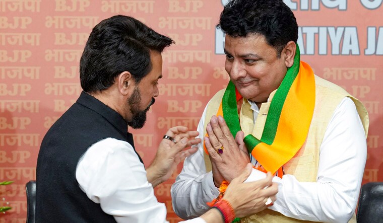 New Delhi: Union Minister Anurag Thakur with former Congress leader Sudhir Sharma as the latter joins Bharatiya Janata Party (BJP), in New Delhi, Saturday, March 23, 2024. (PTI Photo/Kamal Singh)(PTI03_23_2024_000082A)