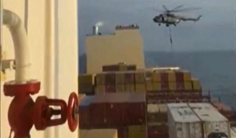 This image grab taken from a UGC video posted on social media on April 13, 2024 shows Iran's Revolutionary Guards rappelling down onto a container ship named, MSC Aries, near the Strait of Hormuz  | AFP