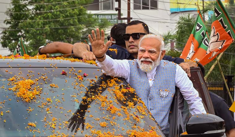 Prime Minister Narendra Modi waves to supporters upon his arrival for a public meeting, ahead of Lok Sabha elections, in Agartala | PTI