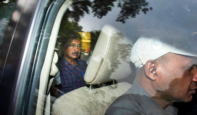 Arvind Kejriwal leaves in a car after attending a hearing at a Delhi court | AP