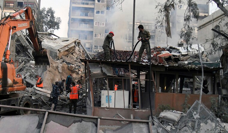 In this photo released by the official Syrian state news agency SANA, emergency service workers clear the rubble at a destroyed building struck by Israeli jets in Damascus, Syria, Monday, April 1, 2024. An Israeli airstrike has destroyed the consular section of Iran's embassy in Syria, killing a senior Iranian military adviser and roughly a handful of other people, Syrian state media said Monday. (SANA via AP)
