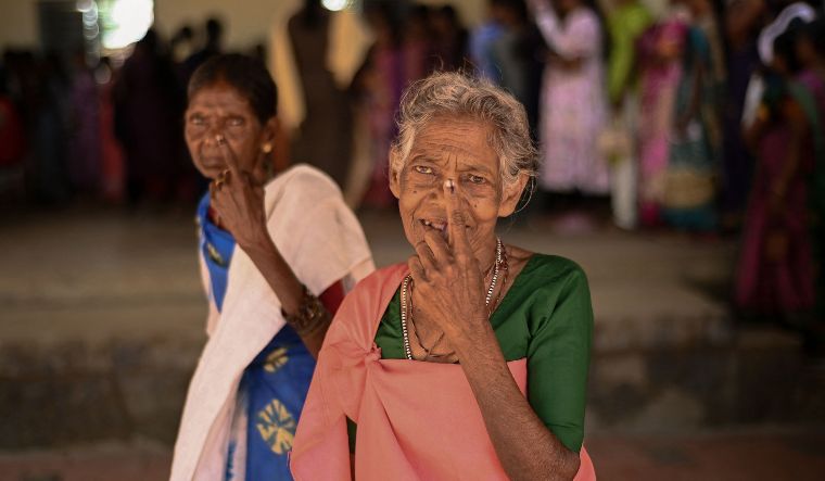 People from Kattunayakar tribe display inked fingers after casting their vote at a polling station during the second phase of voting of India's general election in Wayanad district in Kerala on April 26, 2024 | AFP