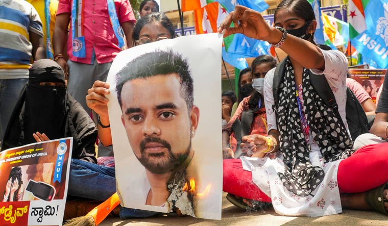 NSUI members burn a poster of JD(S) MP Prajwal Revanna during a protest against his involvement in the alleged sexual abuse case, in Bengaluru