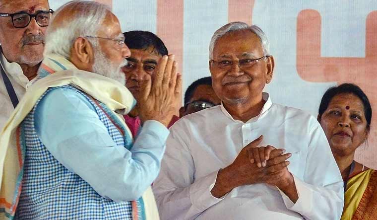 Prime Minister Narendra Modi greets Bihar Chief Minister Nitish Kumar during a public meeting ahead of the Lok Sabha elections, in Nawada | PTI