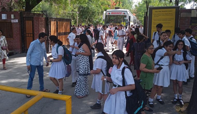 Students and parents outside Delhi Public School, Noida, after several schools received a bomb threat, in Noida | PTI